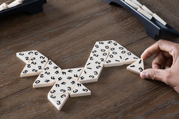 Tuiles triangulaires de Triominos assemblées sur table en bois avec supports de rangement noirs
