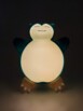 Figurine The Pokemon Company Ronflex debout dans le noir éclairé par une lumière LED intégrée alimentée par 3 piles AAA