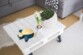 Mise en situation de la lampe LED Ronflex sans fil posée sur une table en bois de palette peinte en blanc installée dans un salon moderne comme veilleuse et décoration