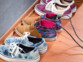 Mise en situation du sèche-chaussures avec chacun de ses modules de séchage placé dans une chaussure dans un pièce avec parquet et mur gris, entouré par d'autre paires de chaussures placées les unes à côté des autres