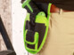Holster AGT Professional noir au liseré vert porté à la ceinture près d’un mur boisé