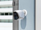 Caméra IP HD fixé à un mur d'immeuble à côté d'une gouttière en extérieur par le biais de son support de fixation magnétique
