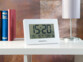Horloge radio-pilotée avec température et date - Blanc Pearl. Mise en situation sur une étagère