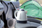 Bouilloire posée sur un siège de voiture au camping pour préparer des boissons chaudes