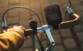 Mise en situation de l'enceinte bluetooth JBL installée sur un guidon de vélo rétro avec la main d'une personne tenant le guidon