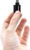 Main d'une personne tenant entre ses doigts le mini adaptateur Dexlan réf. 310700 coloris noir avec fiche USB-C 3.1 Gen 1 et port RJ45 