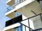 Panneau solaire Full Screen déplié fixé au balcon d'un immeuble moderne un jour ensoleillé