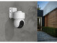 Caméra d'extérieur coloris blanc fixée à un mur gris dans l'allée d'une maison ultra moderne