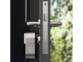 Serrure de porte connectée et intelligente installée dans le trou de serrure d'une porte d'entrée moderne coloris noir avec garniture en alu