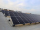 Champ de panneaux solaires montés sur supports métalliques et installés sur le toit d'un immeuble en béton