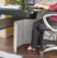 Femme assise sur une chaise travaillant à son bureau et se réchauffant les jambes avec le panneau chauffant infrarouge à 3 niveaux de chauffe sichler haushaltsgeräte